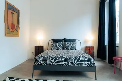 a bedroom with a black and white bed with two lamps at Lyves in Liège
