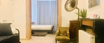 a living room with a couch and a chair and a bedroom at Lyves in Liège