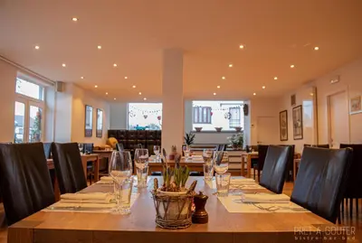 a dining room with a long table with wine glasses at PRET A GOUTER bistro bar bed in Heusden - Zolder