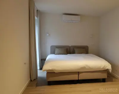 a bedroom with a bed in a white room at PRET A GOUTER bistro bar bed in Heusden - Zolder