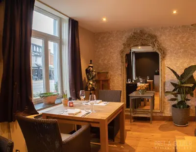 a dining room with a table and a large window at PRET A GOUTER bistro bar bed in Heusden - Zolder