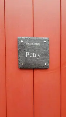 a sign on a red door that reads hulse buffers policy at B&B Huize Briers in Bilzen