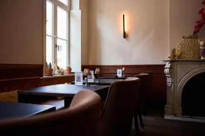 a restaurant with a table and chairs and a fireplace at B&B Huize Briers in Bilzen