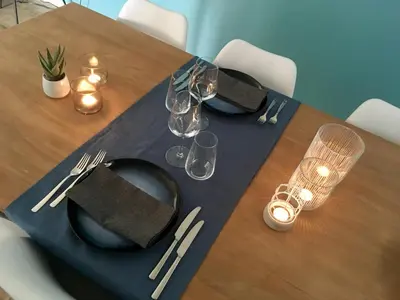 a table with two black plates and glasses on it at L'Inizio Suite in Herve