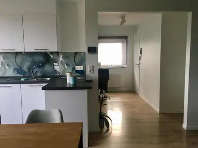 a kitchen with white cabinets and a table and a window at L'Inizio Suite in Herve