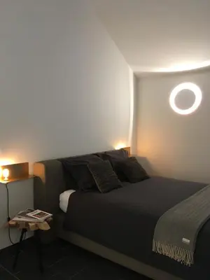 a bedroom with a bed and a round window at De Ruttermolen in Tongeren