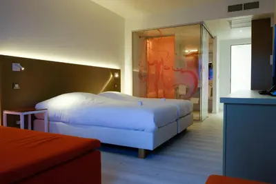 a hotel room with two beds and a mirror at Corbie Lommel Ring in Lommel