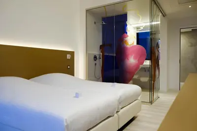 a bedroom with a bed and a large glass shower at Corbie Lommel Ring in Lommel