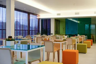 a dining room with tables and chairs and windows at Corbie Lommel Ring in Lommel
