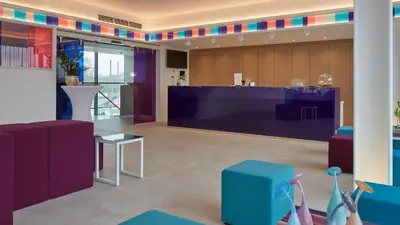 a lobby with purple and blue chairs and a bar at Corbie Lommel Ring in Lommel