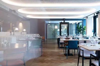 a dining room with white tables and chairs at HasHotel in Hasselt