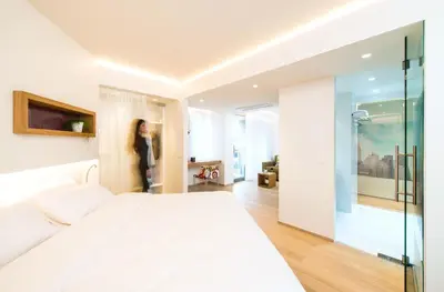 a woman standing in a bedroom with a large bed at HasHotel in Hasselt