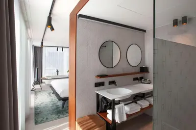 a bathroom with a sink and two mirrors at HasHotel in Hasselt