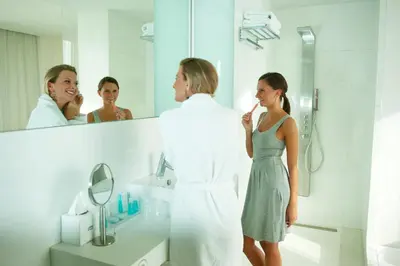 a woman standing in a bathroom with a man brushing her teeth at HasHotel in Hasselt