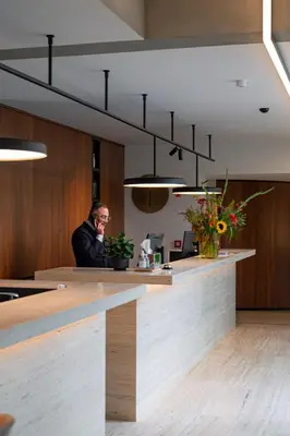 a man talking on a cell phone at a counter at HasHotel in Hasselt