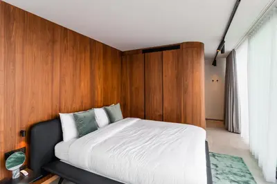 a bedroom with a bed with a wooden wall at HasHotel in Hasselt