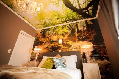 a bedroom with a wall mural of a forest at Villa Valentino in Hasselt