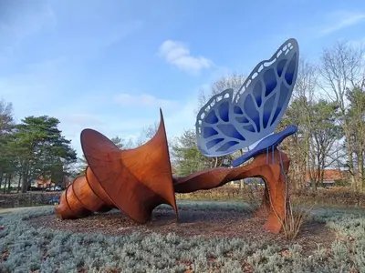 a statue of a butterfly sitting in a field at Hotel De Boskar Peer in Peer