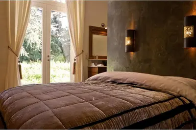 a bedroom with a large bed with a large window at B&B Domaine Villa Bayard in Kanne