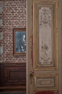 a door with a picture of a man on a brick wall at B&B Domaine Villa Bayard in Kanne