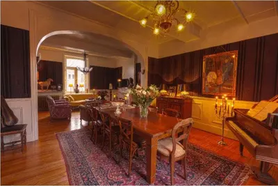 a dining room with a table and a living room at B&B Domaine Villa Bayard in Kanne