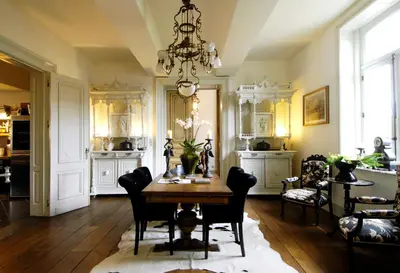 a dining room with a table and chairs and a chandelier at B&B Domaine Villa Bayard in Kanne
