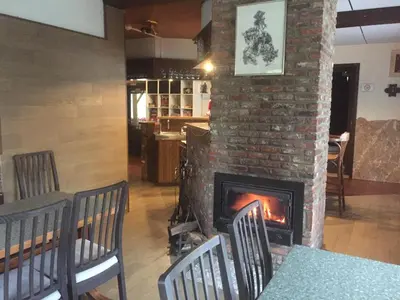 a brick fireplace in a restaurant with chairs and a table at de bron in Beringen