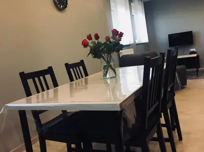 a dining room table with a vase of flowers on it at Rentalis Flat in Liège