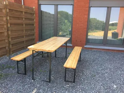 a picnic table and benches in front of a building at Rentalis Flat in Liège