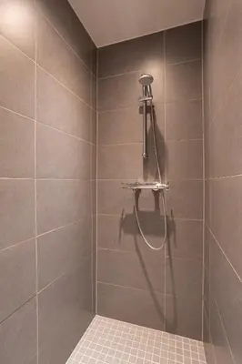 a shower with a shower head in a bathroom at De Villo in Hasselt
