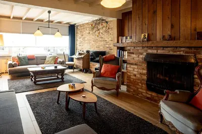 a living room with a fireplace and a brick wall at De Villo in Hasselt
