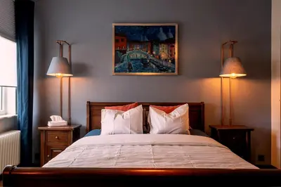 a bedroom with a large bed with two lamps at De Villo in Hasselt