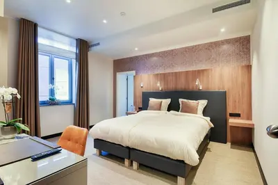 a bedroom with a large bed and a desk at twee broeders in Riemst