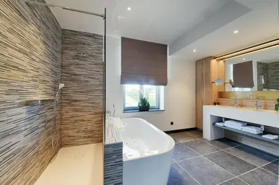 a bathroom with a tub and a sink and a mirror at twee broeders in Riemst