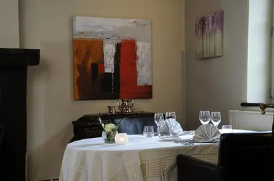 a dining room with a table with wine glasses at twee broeders in Riemst