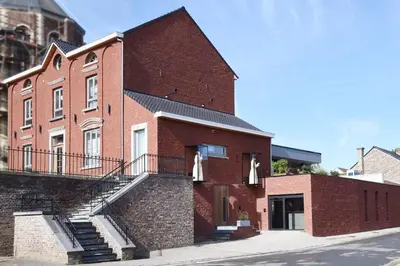 a red brick building with stairs on the side of it at twee broeders in Riemst