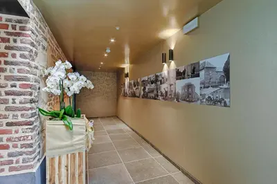 a hallway with a brick wall with a vase of flowers at twee broeders in Riemst