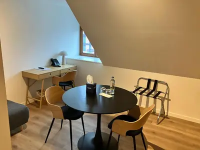 a room with a table and chairs and a desk at Hotel De Groene Hendrickx in Hasselt