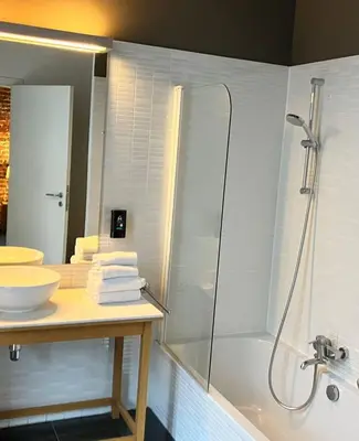 a bathroom with a shower and a sink and a tub at Hotel De Groene Hendrickx in Hasselt