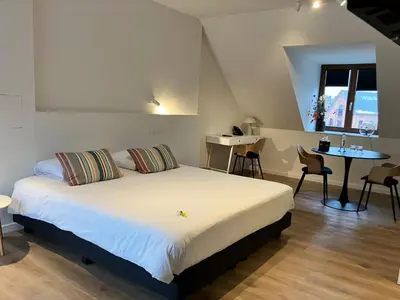 a bedroom with a bed and a table and chairs at Hotel De Groene Hendrickx in Hasselt