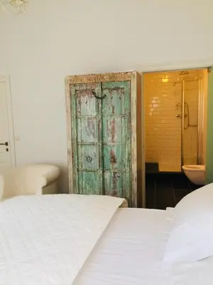 a bedroom with a bed and a green door at Kirisavan Bed&Breakfast in Borgloon