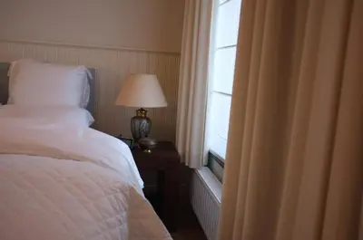 a bedroom with a bed with a lamp and a window at Kirisavan Bed&Breakfast in Borgloon
