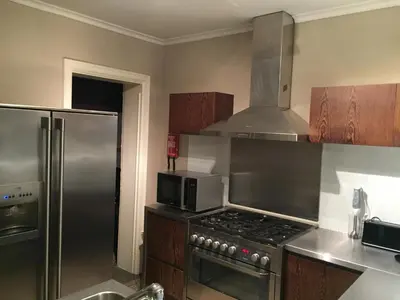 a kitchen with a stove and a stainless steel refrigerator at Hollandia City Distillery in Hasselt
