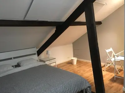 a bedroom with a bed and a table and chairs at Hollandia City House in Hasselt