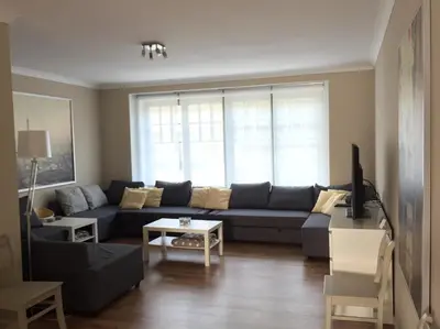 a living room with a blue couch and a window at Hollandia City House in Hasselt