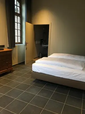 a bedroom with a bed and a tiled floor at Orshof in Oudsbergen