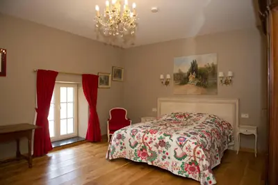 a bedroom with a bed and a chandelier at B&B Kamerijck in Gingelom