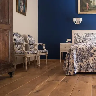 a bedroom with blue walls and a bed and two chairs at B&B Kamerijck in Gingelom