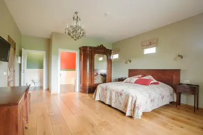 a bedroom with a bed and a chandelier at B&B Kamerijck in Gingelom