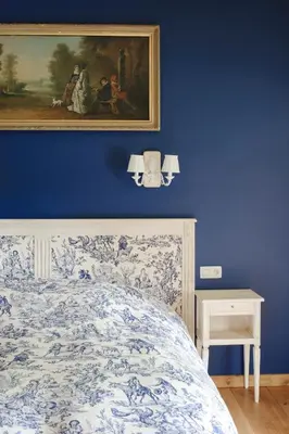 a blue bedroom with a painting above a bed at B&B Kamerijck in Gingelom